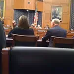 photo of people sitting at a house hearing