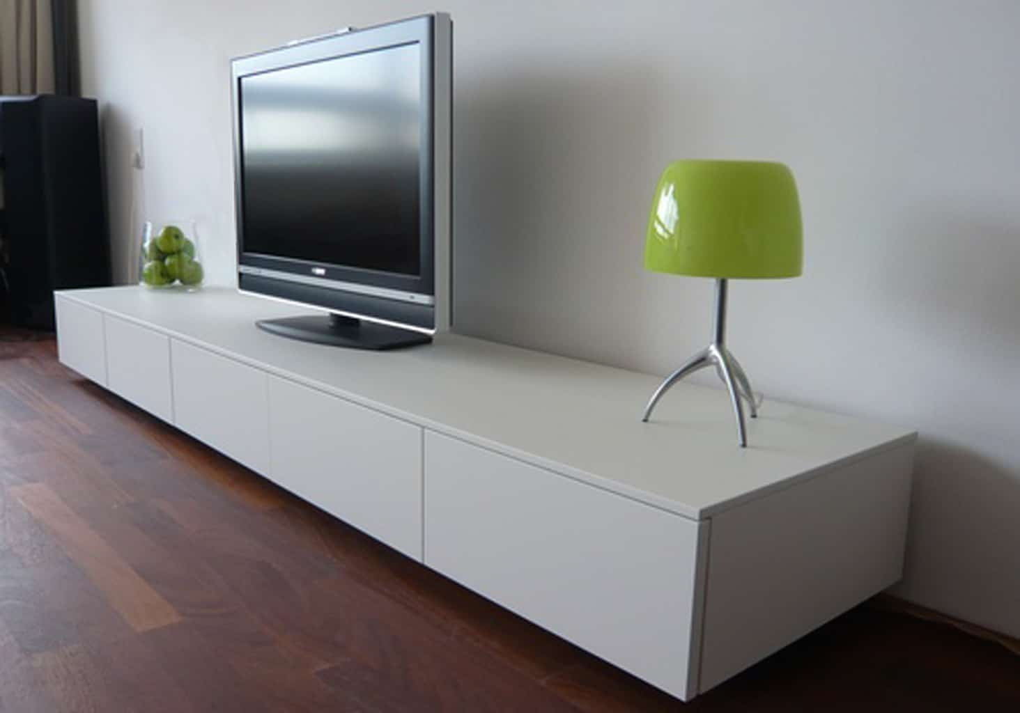 A large flat screen TV sits on a modern looking white console table