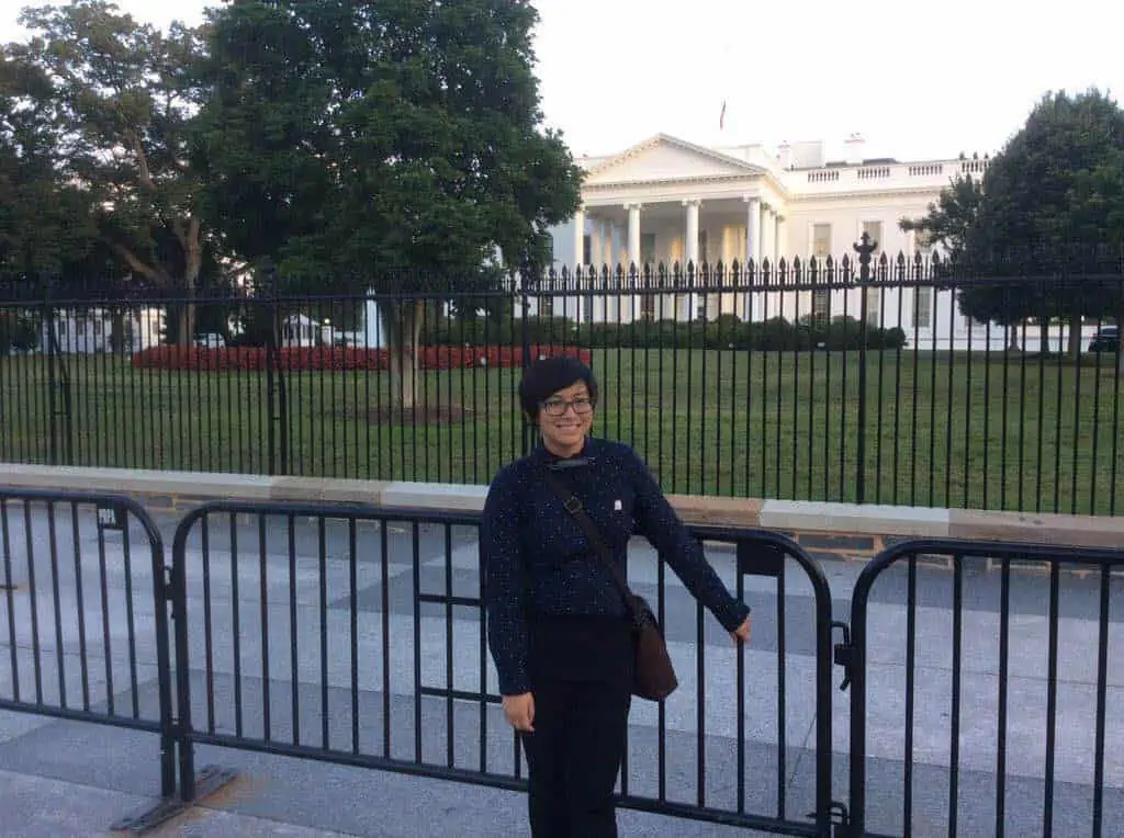 [A person named Elly Wong stands in front of the White House.]