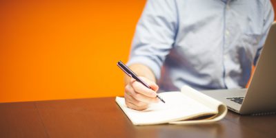 a hand writing a letter