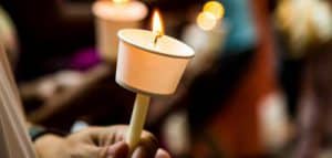 Closeup Of People Holding Candle Vigil In Dark Seeking Hope