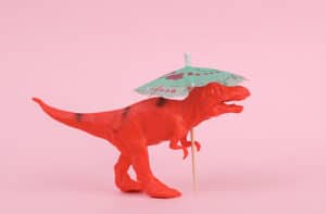 a toy dinosaur holding an umbrella